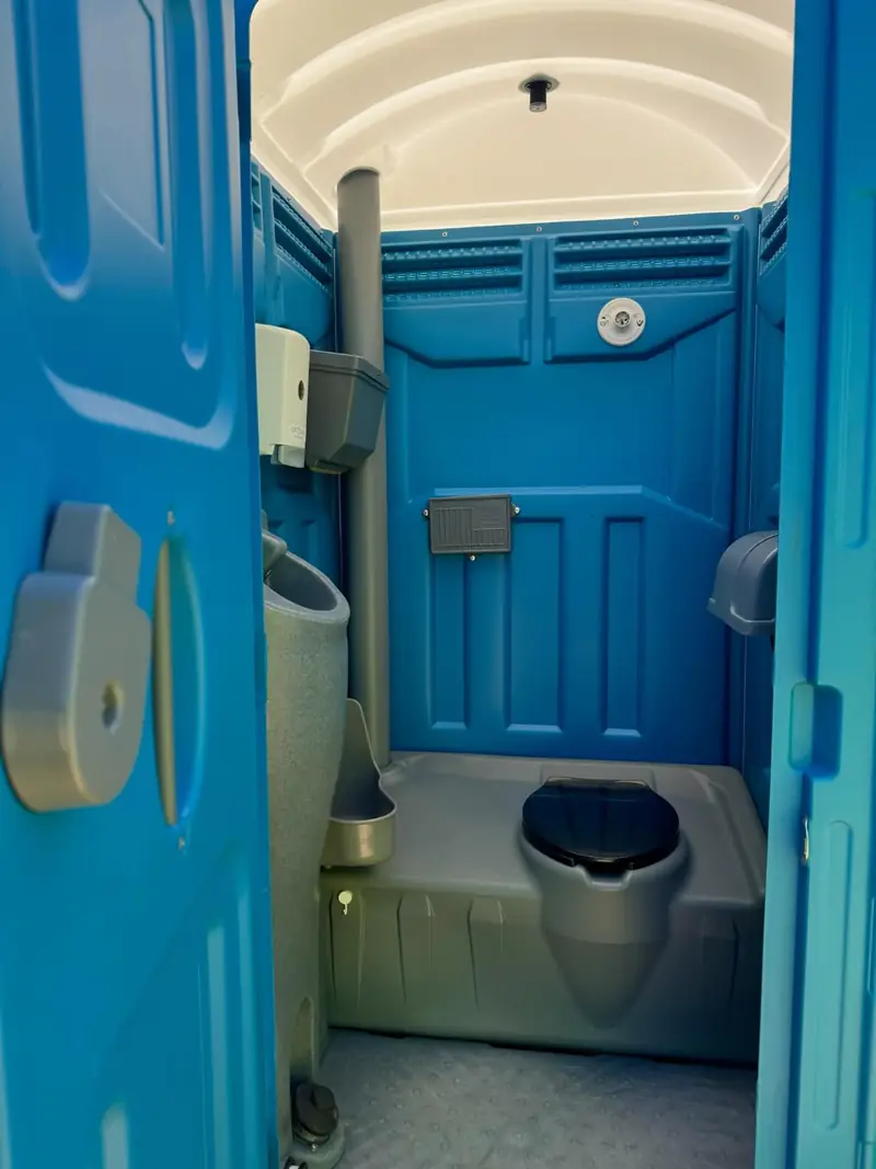 Clean interior of a blue porta potty with light coming in
